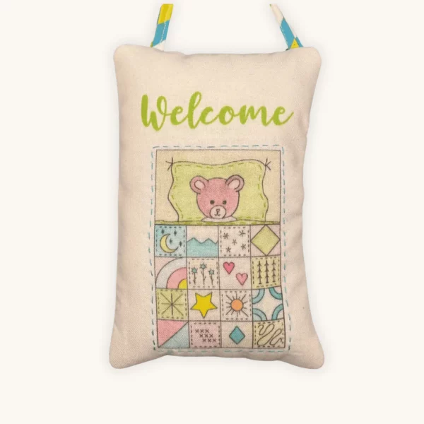 A completed nap time doorknob pillow embroidery kit by the Posy Collection