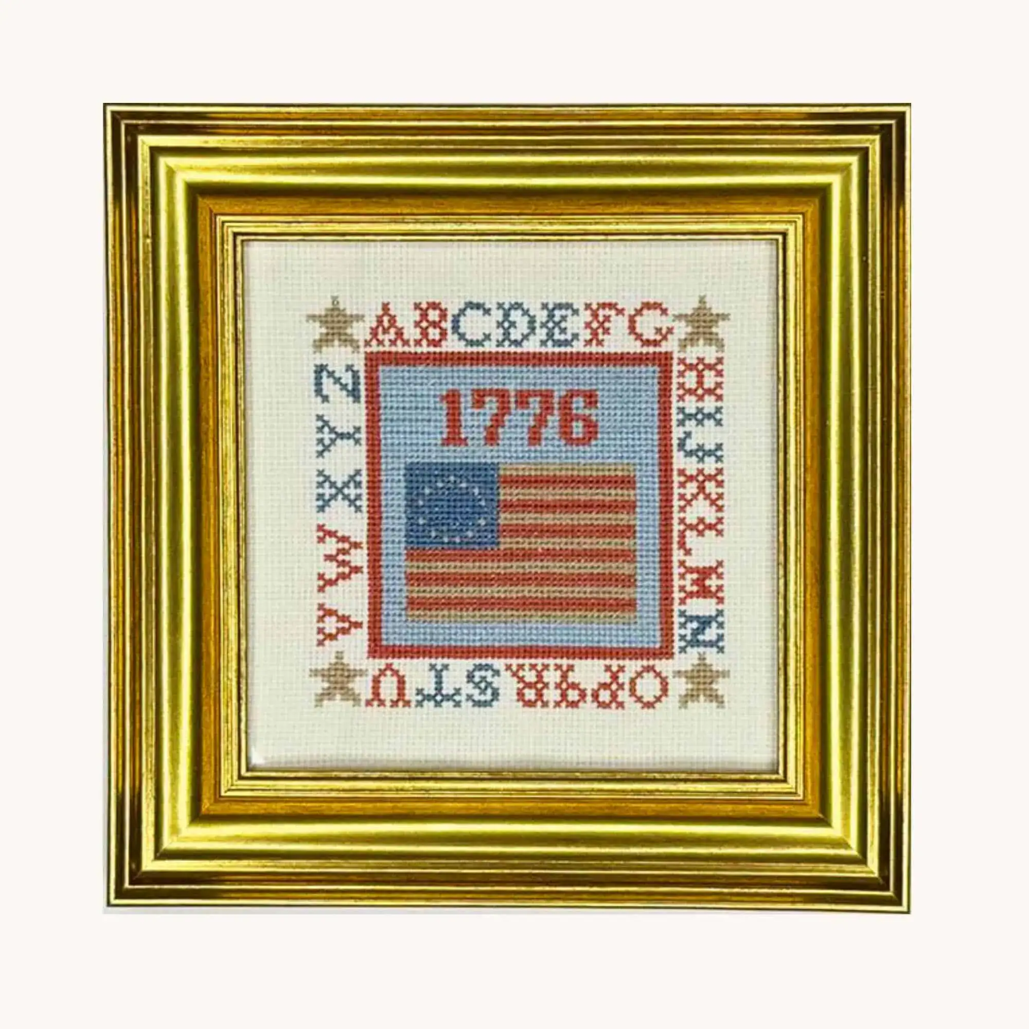 A completed 1776 Colonial Flag cross stitch kit by the Posy Collection displayed in a frame.