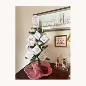 A completed Lady Liberty Patriotic Redwork kit by the Posy Collection displayed on a small table top tree.